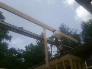 Carpenter setting a ridge beam over a new addition frame — Ice Dam Removal by Roofing Brothers in Moreno Valley