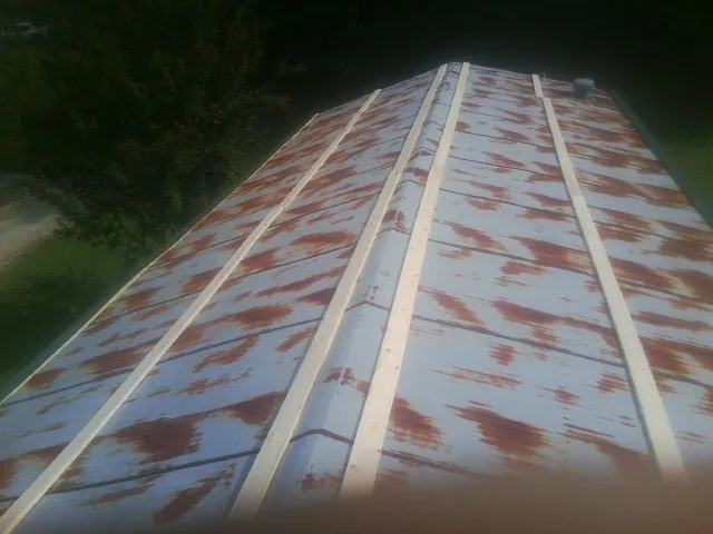 Rusted metal roof panels with new wood purlins before replacement — Storm Damage Roof Repair in Moreno Valley by Roofing Brothers