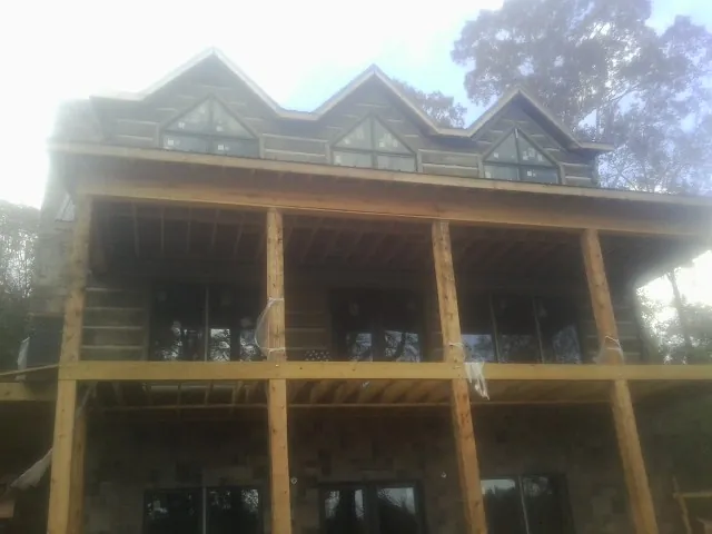 Dormers and porch framing on a large log home under construction — Roof Coating work by our crew in Moreno Valley